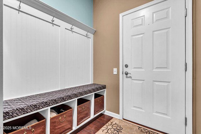 mudroom with dark wood-type flooring and baseboards