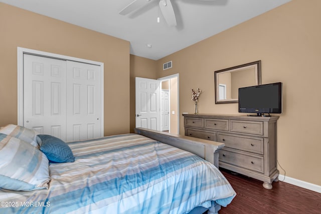 bedroom with a closet, visible vents, baseboards, ceiling fan, and dark wood finished floors