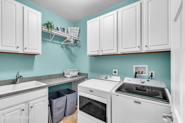 laundry area with washing machine and clothes dryer, a sink, and cabinet space