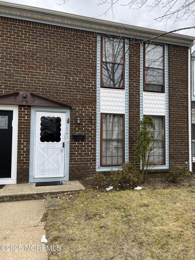 entrance to property featuring brick siding