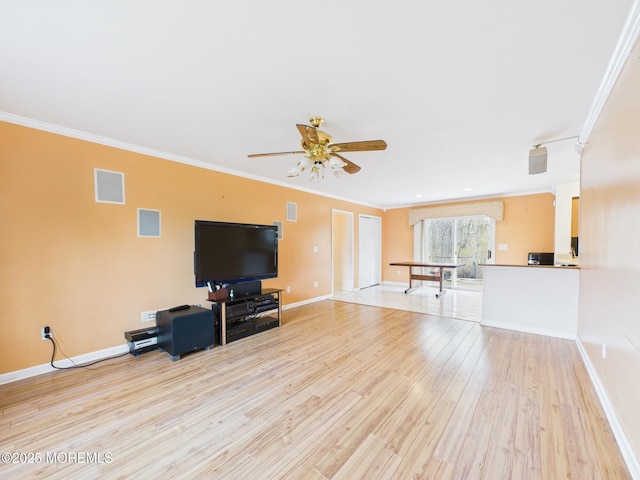 living room with light wood-type flooring, crown molding, a ceiling fan, visible vents, and baseboards