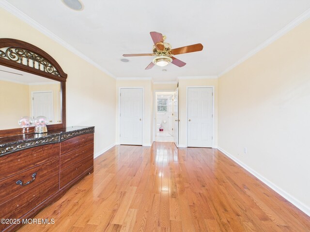 interior space featuring baseboards, crown molding, and light wood-style flooring