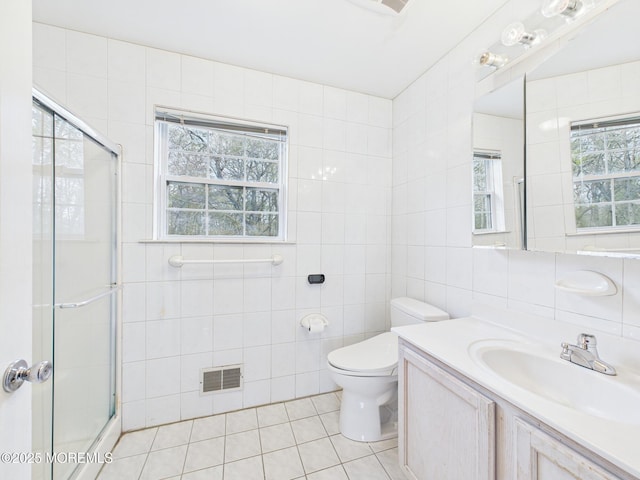 bathroom with tile patterned flooring, a stall shower, and tile walls