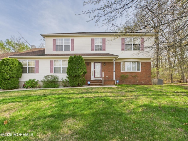 view of front of home featuring a front lawn, entry steps, and brick siding