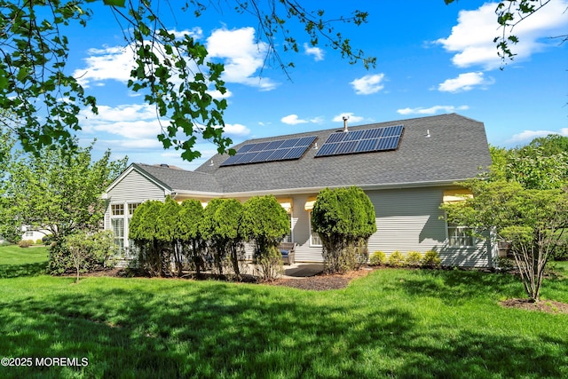 1505 Wishing Well Ln, Manasquan, NJ 08736 - back of property featuring a lawn, roof mounted solar panels, and a shingled roof