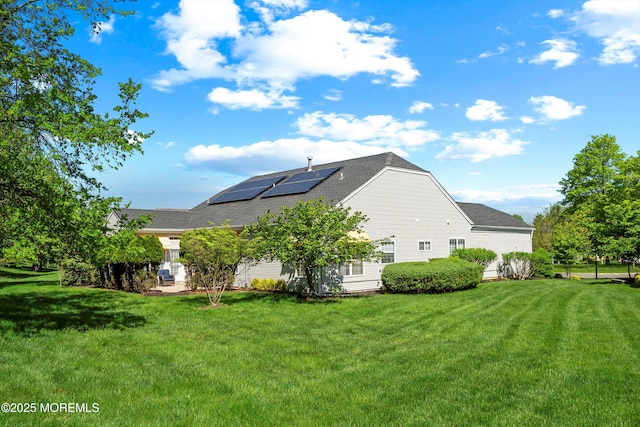1505 Wishing Well Ln, Manasquan, NJ 08736 - rear view of property with roof mounted solar panels, a yard, and roof with shingles