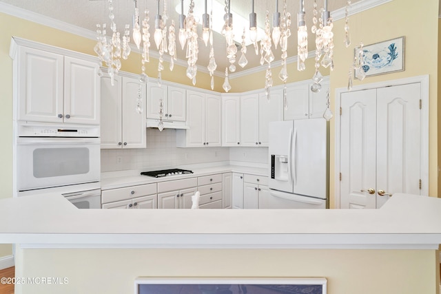 1505 Wishing Well Ln, Manasquan, NJ 08736 - kitchen with white appliances, ornamental molding, light countertops, white cabinets, and backsplash
