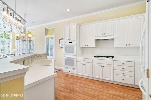 1505 Wishing Well Ln, Manasquan, NJ 08736 - kitchen with white appliances, ornamental molding, under cabinet range hood, light wood-type flooring, and white cabinetry