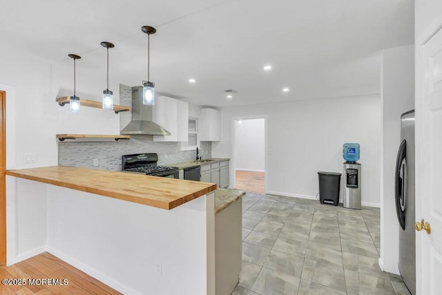 115 Leesville Rd, Jackson, NJ 08527 - kitchen with wall chimney range hood, black appliances, wood counters, and a peninsula