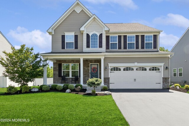 view of front of house with a garage, driveway, stone siding, and covered porch