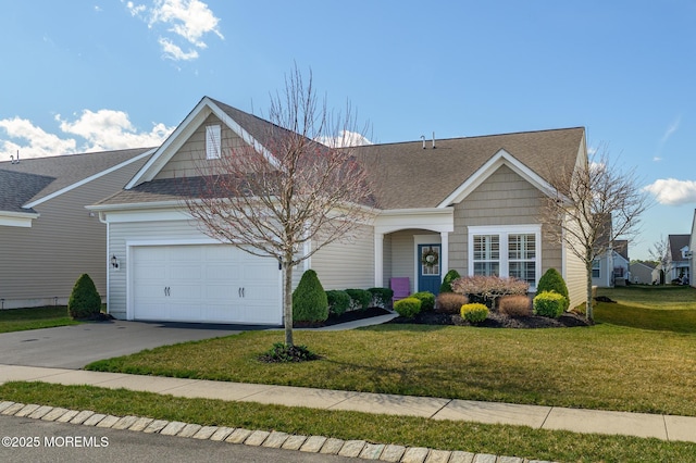 view of front facade with a front yard, concrete driveway, roof with shingles, and an attached garage
