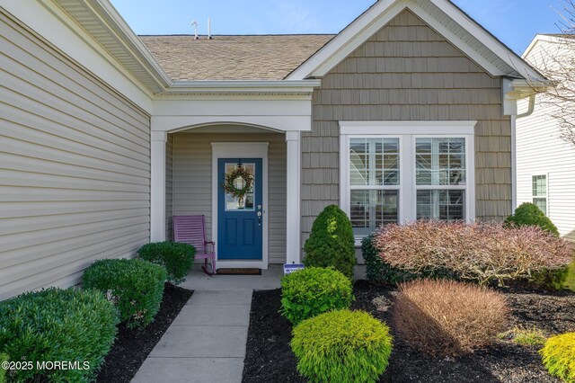 entrance to property with roof with shingles