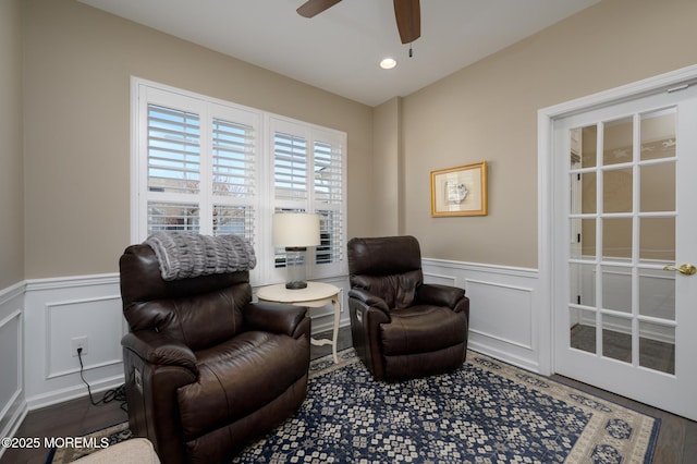 living area with a wainscoted wall, wood finished floors, recessed lighting, and a ceiling fan