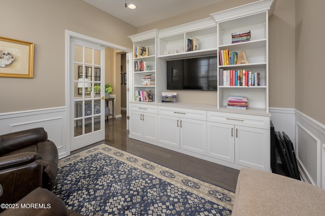living room featuring a wainscoted wall, dark wood finished floors, and recessed lighting