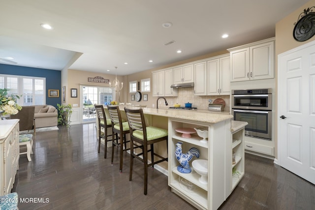 kitchen featuring decorative backsplash, white cabinets, appliances with stainless steel finishes, dark wood-type flooring, and open shelves