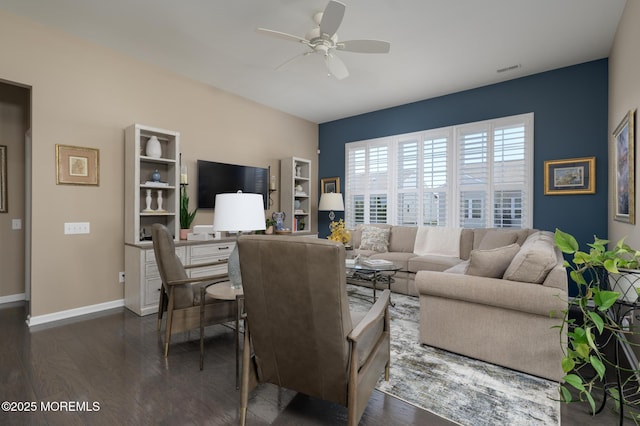 living area featuring baseboards, dark wood-style floors, visible vents, and a ceiling fan