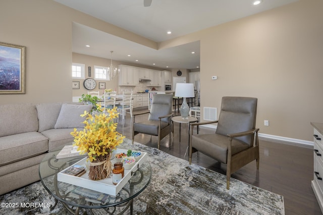 living area with dark wood finished floors, baseboards, visible vents, and recessed lighting