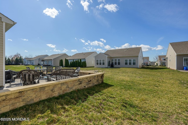back of house featuring a residential view, a yard, and a patio area
