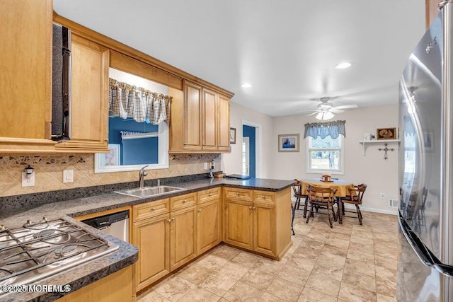 kitchen featuring dark countertops, backsplash, a sink, and stainless steel appliances