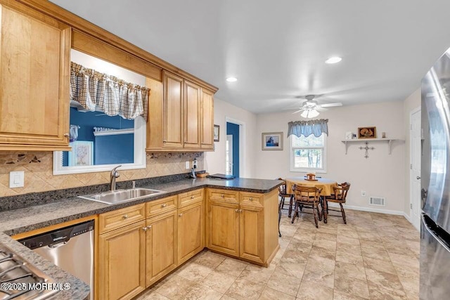 kitchen featuring tasteful backsplash, a sink, visible vents, a peninsula, and appliances with stainless steel finishes