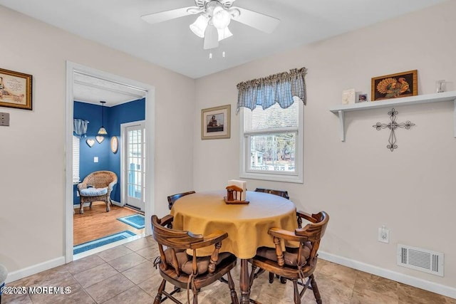 dining space featuring visible vents, a ceiling fan, light tile patterned floors, and a healthy amount of sunlight