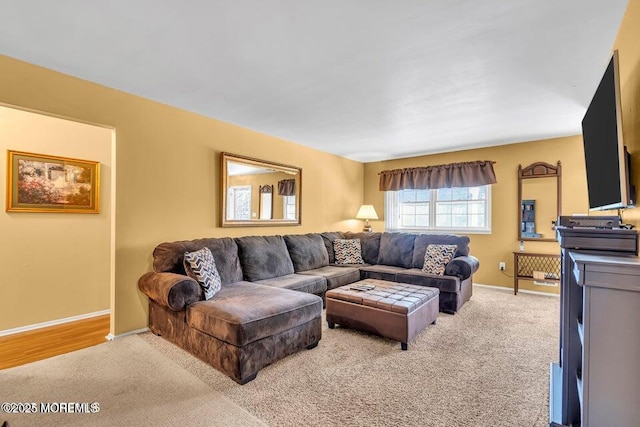 living area with baseboards and light colored carpet