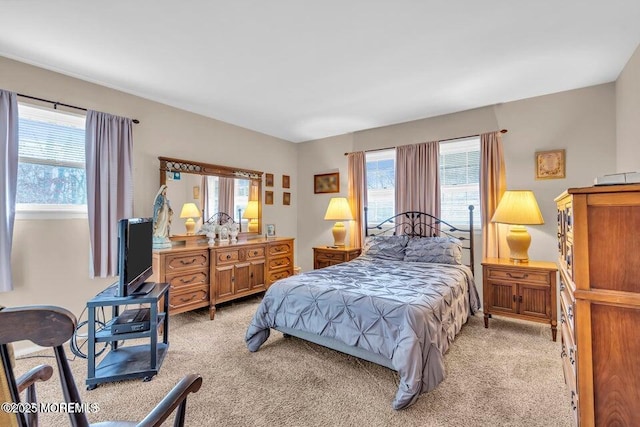 bedroom with light carpet and multiple windows