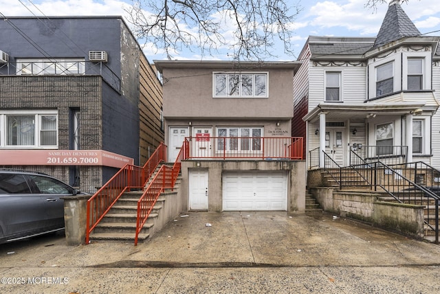 2776 John F Kennedy Blvd, Jersey City, NJ 07306 - townhome / multi-family property with stairway, concrete driveway, stucco siding, an attached garage, and a porch