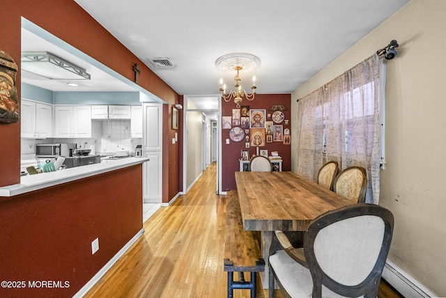2776 John F Kennedy Blvd, Jersey City, NJ 07306 - dining area featuring light wood-type flooring, baseboards, a chandelier, visible vents, and baseboard heating