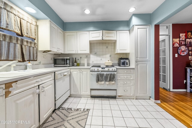 2776 John F Kennedy Blvd, Jersey City, NJ 07306 - kitchen featuring light countertops, tasteful backsplash, white appliances, a sink, and white cabinets