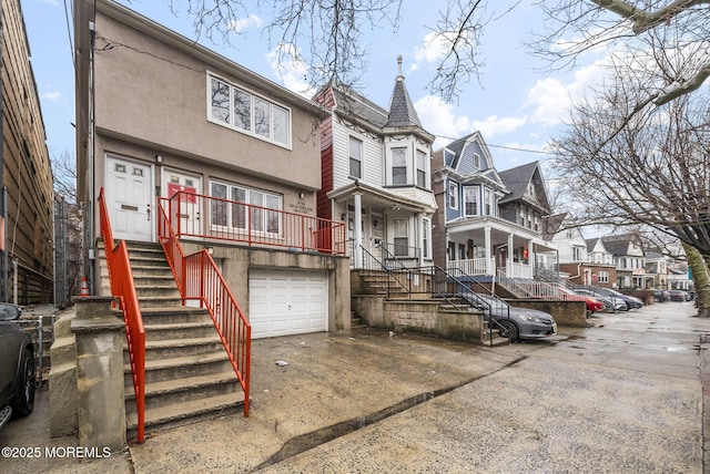 2776 John F Kennedy Blvd, Jersey City, NJ 07306 - view of front of property featuring driveway, a garage, stairway, a residential view, and stucco siding
