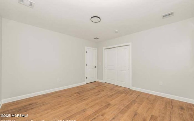 unfurnished room with baseboards, visible vents, and light wood-style floors