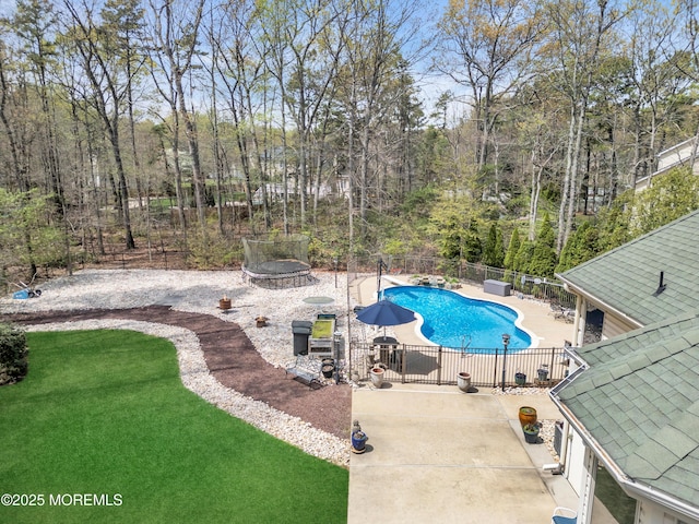 view of pool with a fenced in pool, a trampoline, a patio area, fence, and a yard