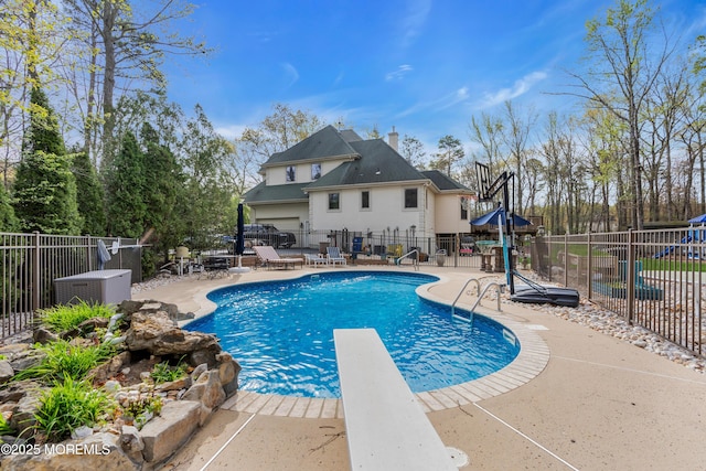 view of swimming pool with fence, a diving board, a patio area, and a fenced in pool
