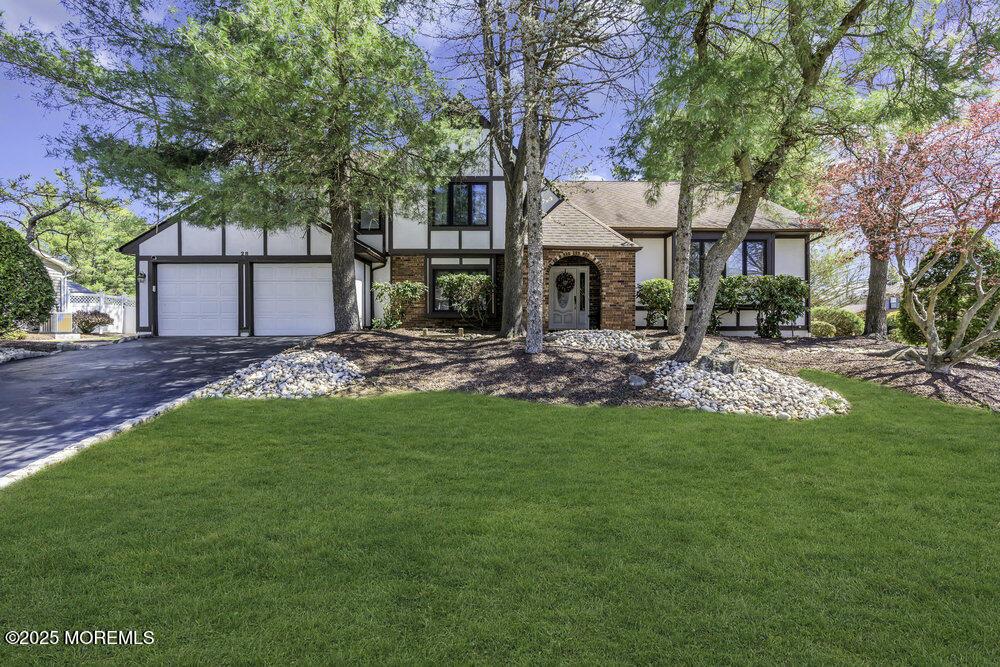 28 Pheasant Dr, Marlboro, NJ 07746 - tudor-style house featuring driveway, a front lawn, and roof with shingles