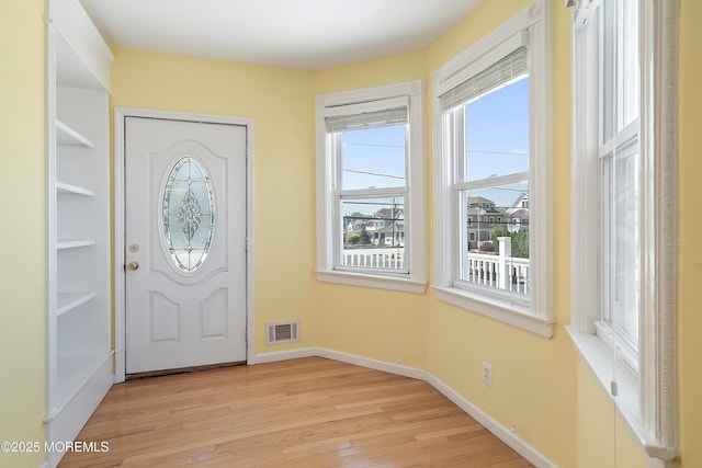 entryway with light wood-type flooring and baseboards