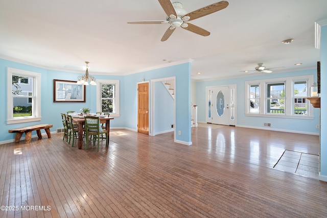 dining area with stairway, crown molding, ceiling fan, hardwood / wood-style floors, and baseboards