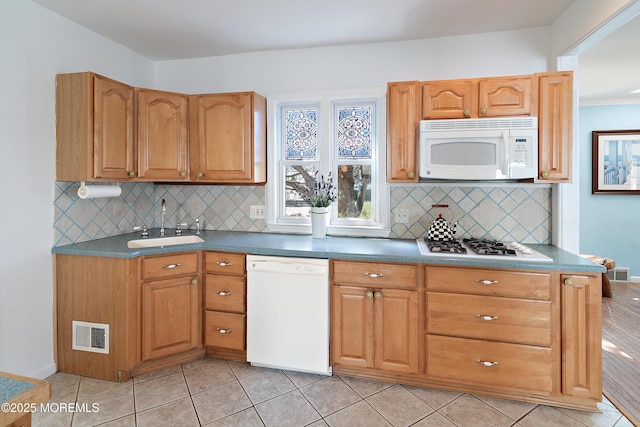 kitchen with white appliances, a sink, decorative backsplash, and light tile patterned floors