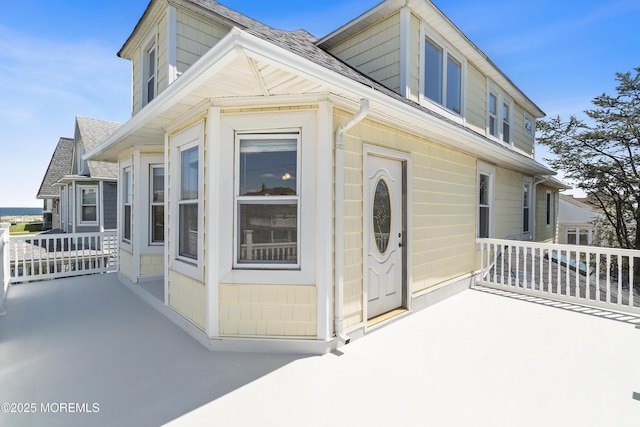 view of side of home with a shingled roof