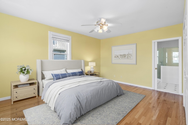 bedroom with wood finished floors, baseboards, connected bathroom, and a ceiling fan