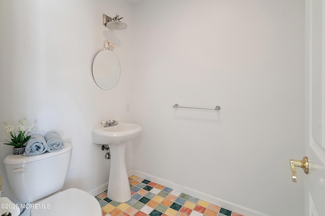 half bathroom with toilet and baseboards