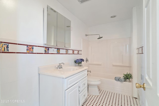 bathroom with tile walls, vanity, bathtub / shower combination, toilet, and tile patterned flooring
