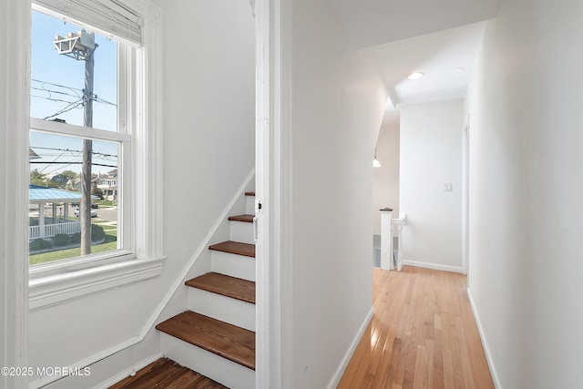 stairs featuring wood finished floors, baseboards, and recessed lighting