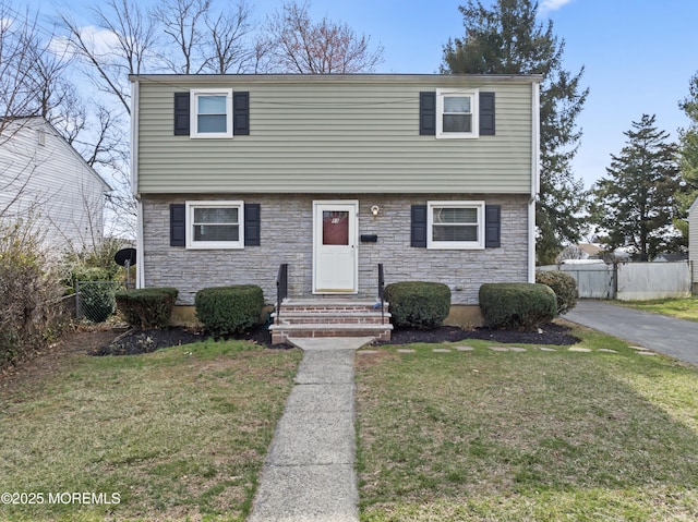 89 Barkalow Ave, Freehold, NJ 07728 - colonial-style house with a front yard, fence, and stone siding