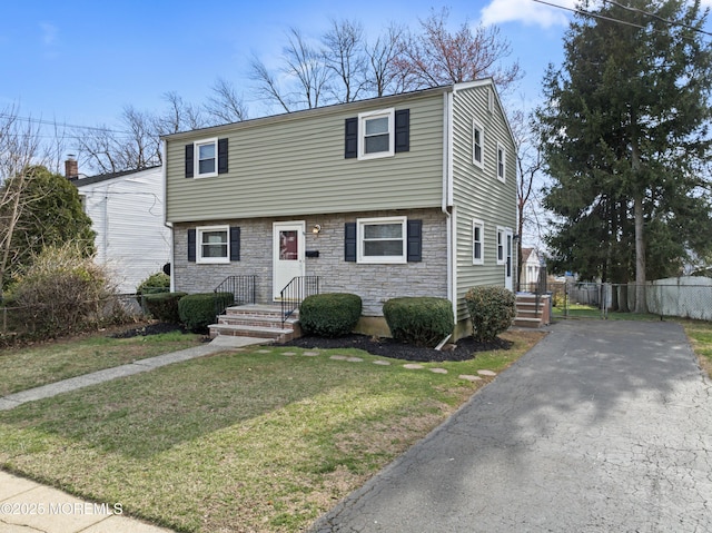 89 Barkalow Ave, Freehold, NJ 07728 - colonial inspired home with driveway, stone siding, fence, and a front lawn