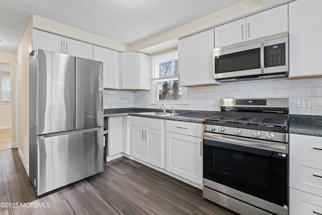89 Barkalow Ave, Freehold, NJ 07728 - kitchen featuring dark wood-style flooring, white cabinetry, dark countertops, stainless steel appliances, and a sink
