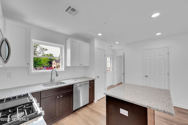 42 W Shore St, Keansburg, NJ 07734 - kitchen with stainless steel dishwasher, a sink, gas range oven, light wood-type flooring, and light stone counters