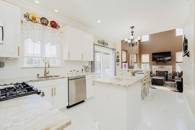 19 Summerhill Ave, Jackson, NJ 08527 - kitchen with a notable chandelier, light stone counters, gas range, stainless steel dishwasher, and a sink