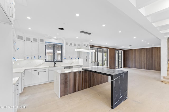 18 Seaview Ave, Long Branch, NJ 07740 - kitchen with a sink, wooden walls, white cabinetry, glass insert cabinets, and a center island