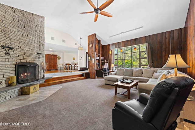 113 Parker Rd, West Long Branch, NJ 07764 - living area with high vaulted ceiling, carpet floors, a stone fireplace, ceiling fan, and wooden walls